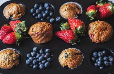 Blueberry and strawberry muffins with berries. Close up. Top view. - 535918899