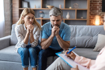 Sad mature caucasian wife and husband listening to doctor in clinic office interior at meeting with...