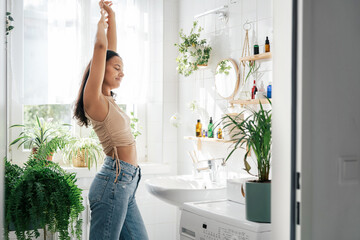 Young woman stretching in bathroom. Body positivity, confort home zone, wellness and lifestyle