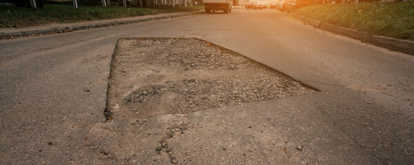 Large road pothole on asphalt surface during street repair on local urban street