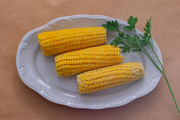 three ears of corn in a white bowl