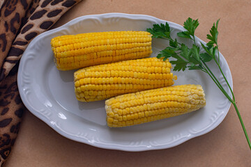 three ears of corn in a white bowl