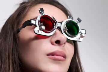 Attentive optometrist examines a beautiful female patient, checks her vision in an ophthalmological...