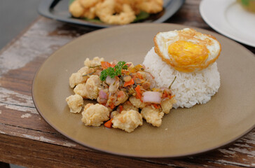 Rice with fried egg and vegetables on plate. Fried egg rice on the table ready to eat