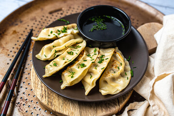Homemade fried Asian potsticker dumpling appetizer. Gyzo Asian Pork Potstickers with Soy Sauce. Dumplings on a plate.
