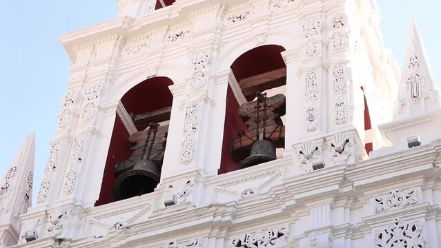 Vista en contrapicada de campanario en iglesia blanca