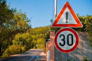 road signs warning of danger and limiting the maximum permissible speed to 30 kilometers per hour,...