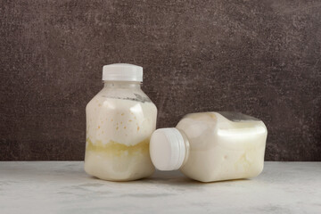 Spoiled dairy products in disposable plastic bottles. Bloated swollen bottles. Fermented sour milk....