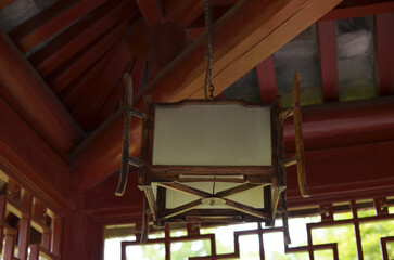 Decorative asian wooden lamp hanging in room. Interior design