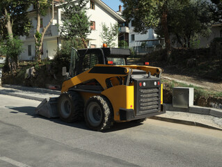Obraz na płótnie Canvas Modern skid loader on city street. Road repair