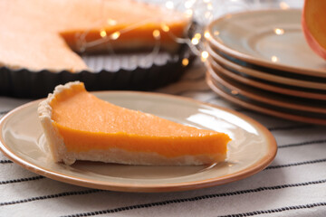 Plate with piece of fresh homemade pumpkin pie on table