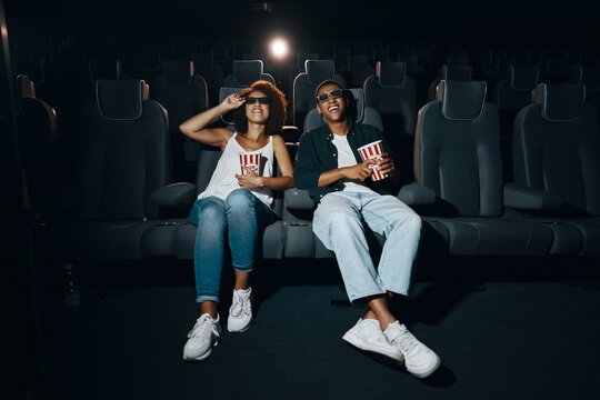 Couple watching movie with popcorn in cinema.