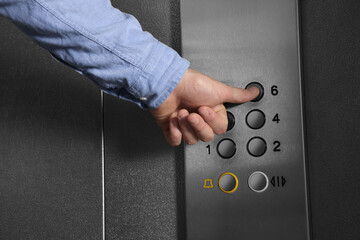 Man choosing floor in elevator, closeup view