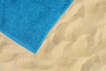 Fototapeta na wymiar Soft blue beach towel on sand, top view. Space for text