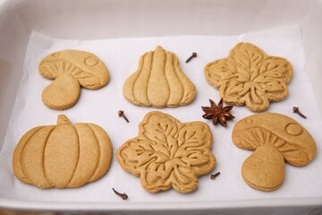 Different tasty cookies and spices on white parchment