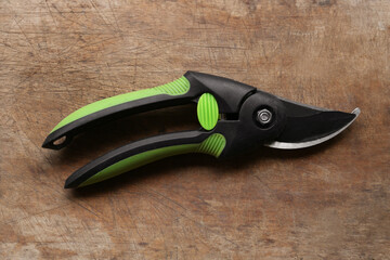 Obraz premium Secateur on wooden table, top view. Gardening tool