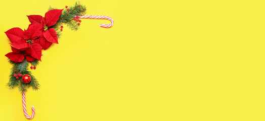 Beautiful composition with Christmas decorations and poinsettia flowers on yellow background with space for text