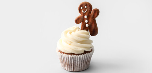Tasty Christmas cupcake with gingerbread cookie on light background