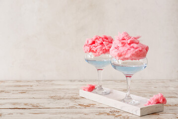 Glasses with tasty cotton candy cocktail on light wooden table