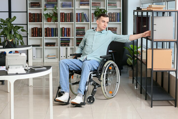 Young man with physical disability working in office