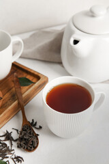 Composition with hot black tea on white table