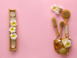 Composition with bath accessories and tropical flowers on pink background