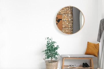 Interior of stylish hall with round mirror and bench