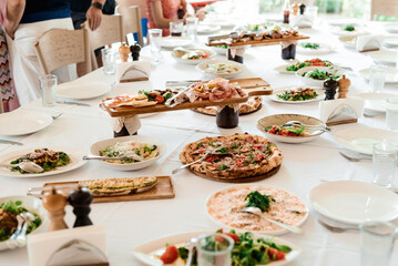 Top of view full table of italian meals on plates and pan. Pizza pasta risotto soup and fish vegetable salad.