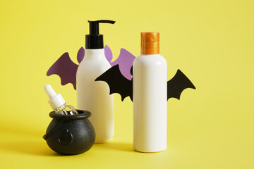 creative composition of mock-up bottles of cosmetics and halloween decor