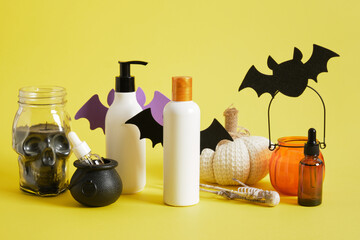 creative composition of mock-up bottles of cosmetics and halloween decor