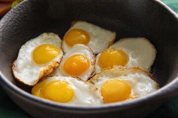 Frying pan with fried quail eggs, closeup