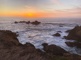 Waves crashing on rocks with sunset in Northern California 