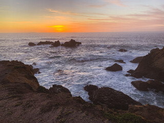 Fototapeta na wymiar Waves crashing on rocks with sunset in Northern California 