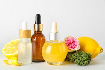 Composition with bottles of citrus serum on grey background