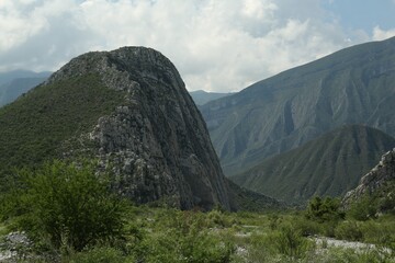 Picturesque view of beautiful mountains and plants under cloudy sky
