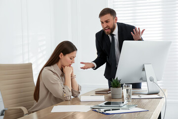 Boss screaming at employee in office. Toxic work environment - obrazy, fototapety, plakaty