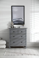 Stylish room interior with grey chest of drawers and beautiful picture
