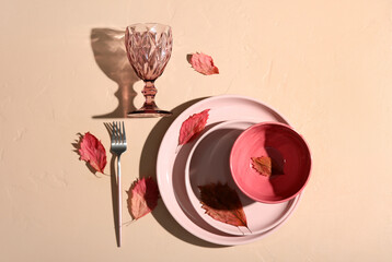 Autumn table setting with fallen leaves on beige background