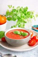 Bowl with delicious tomato soup on light table, closeup