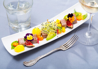 Image of delicious fried tuna with mango, avocado and fig, served with flower