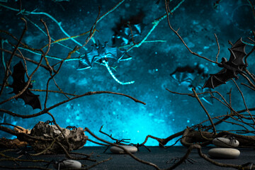 Halloween scary dark blue background with twisted branches, bats, stones and spiders, copy space