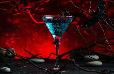 Halloween witch potion alcoholic cocktail on scary dark red background with twisted branches, bats, stones and spiders,  festive drink for party