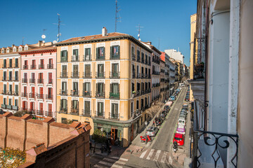 Fototapeta premium Facades of old residential buildings at a crossroads with cobbled paths, balconies, a wall and zebra crossings