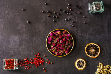 Autumn print with dry leaves of rose tea buds, dehydrated orange slices, red pepper and juniper fruits