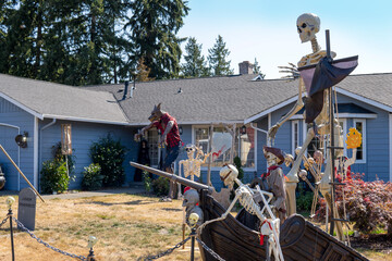 House yard decorated for Halloween with skulls, skeletons, graves, werewolf, pirate ship