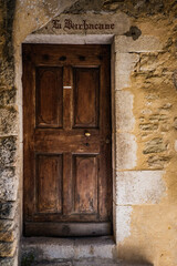 Old wooden door of a medieval stone house in the village of Saint Montan in Ardeche (South of France)