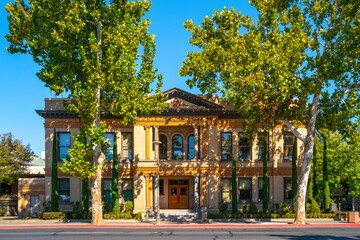 Old Chico City Hall, view from the street, the autumn landscape behind tall sycamore trees, Chico,...