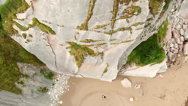 Top-down shot over a cliff showing people relaxing on the stunning Itzurun Beach