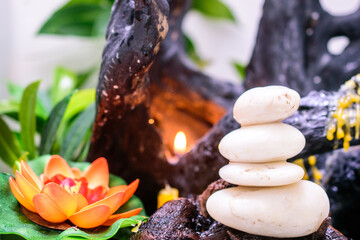 Zen stones and lotus flowers are lit by candlelight.