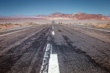 Fototapeta premium Asphalt road in Atacama desert, volcanic arid landscape in Chile, South America